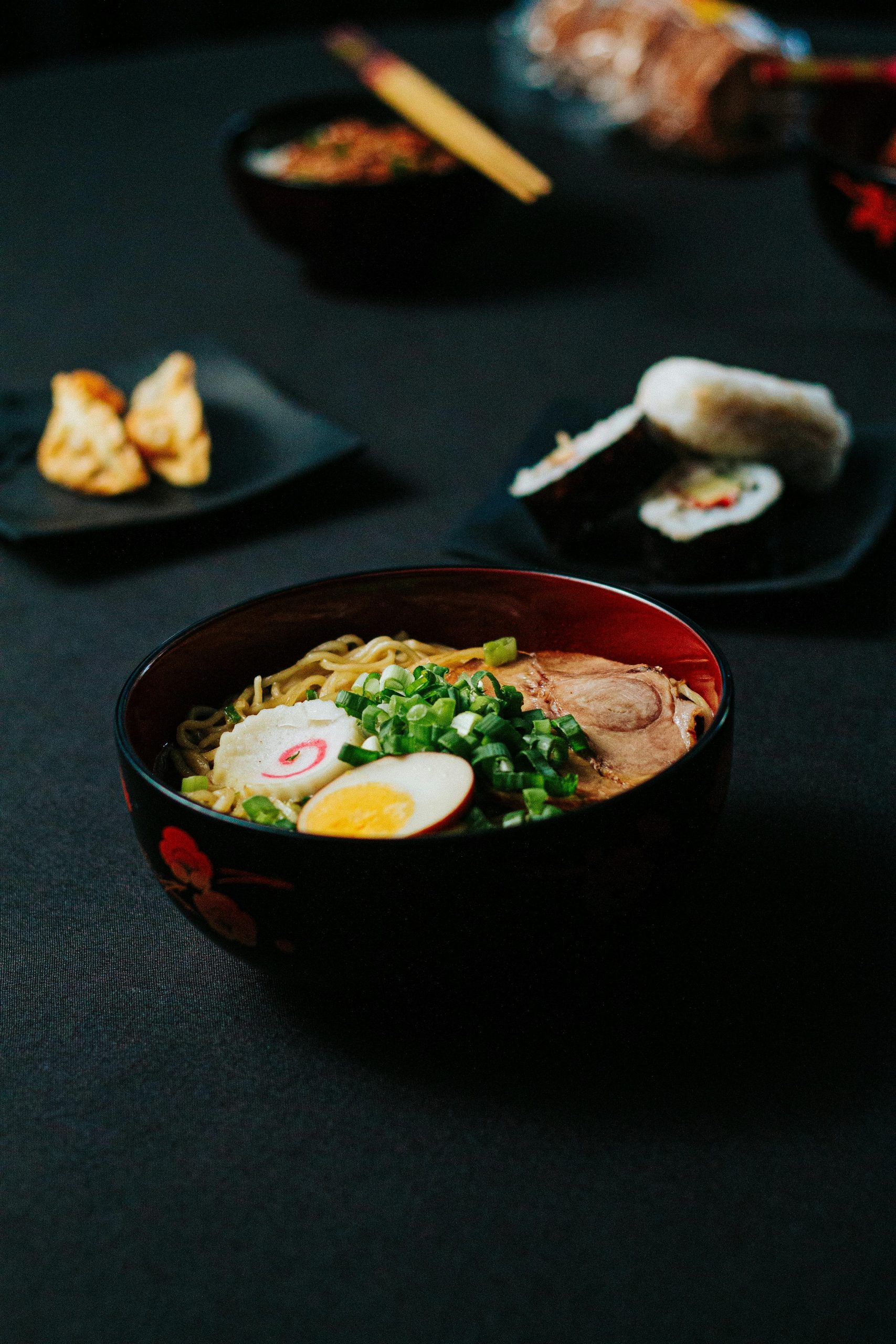 Delicious bowl of ramen with sushi and appetizers, showcasing traditional Japanese cuisine.